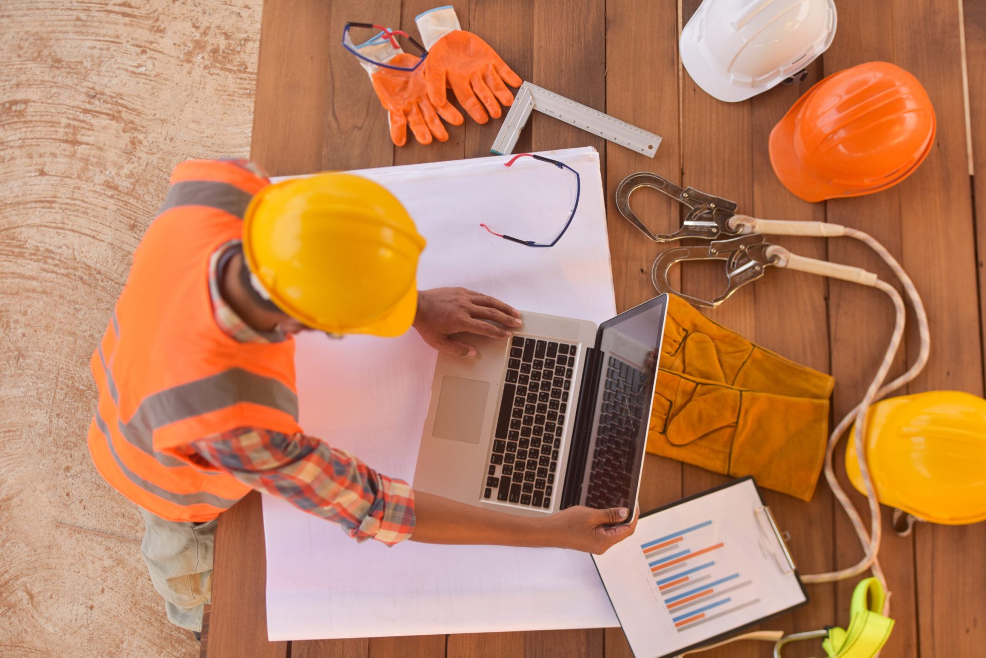 top view of architectural engineer useing laptop on his blueprin
